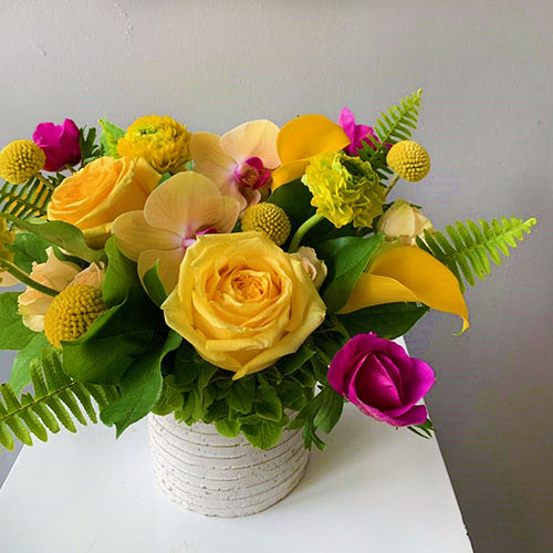A male pair of hands carefully trims the stems of a flower grouping